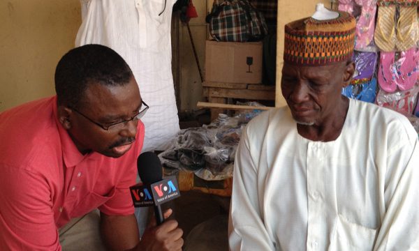 Photo of VOA's Ibrahim Ahmed interviewing man in Nigeria.