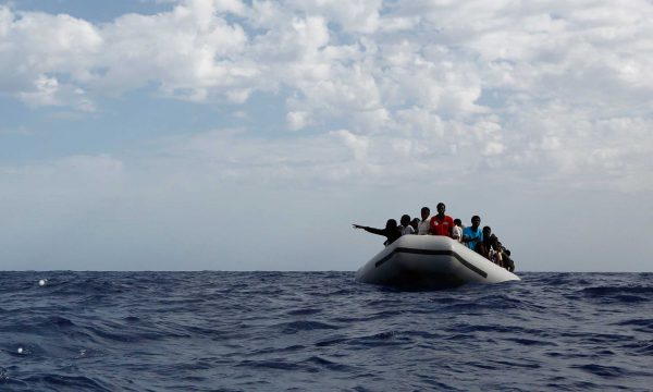 A rubber boat filled with Africans on the open sea.