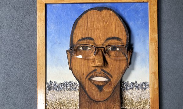 photo of sculpted portrait made with wood and real glasses