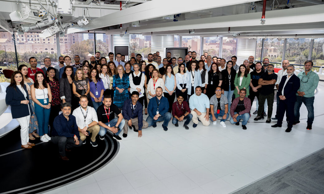 A crowd of people in studio facing the camera for a photo